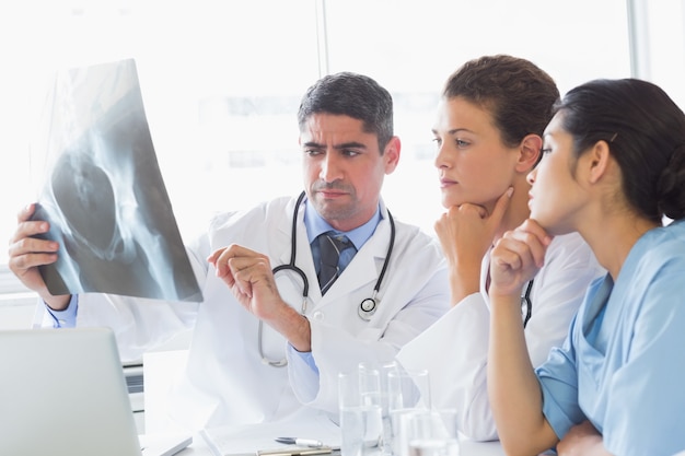 Homme médecin discute de radiographie avec des collègues