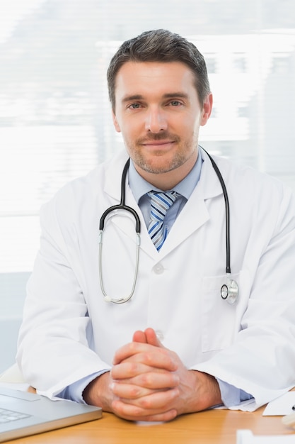 Homme médecin avec ordinateur portable au bureau dans le cabinet médical