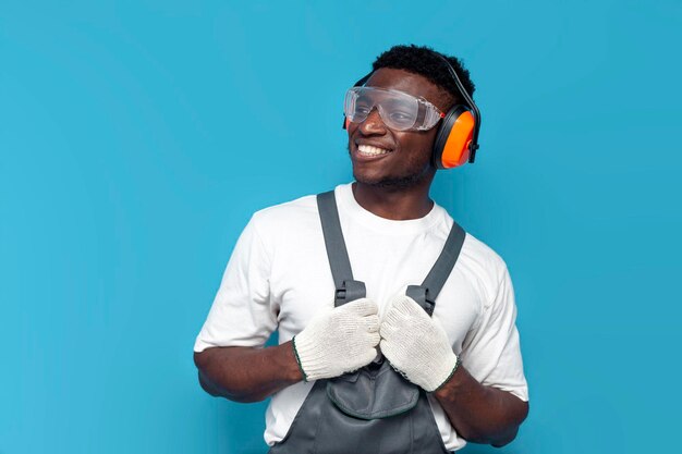 Homme de ménage en uniforme et lunettes de construction regarde loin sur un fond bleu