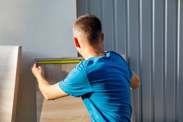 Photo l'homme mesure la longueur des planches