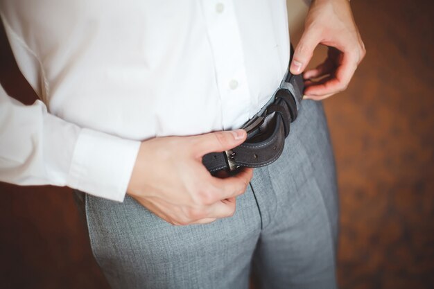 L'homme met une ceinture