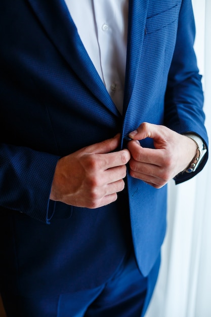 Un homme met un costume d'homme le jour du mariage