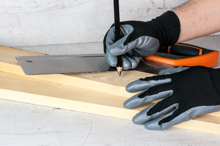 Photo un homme met des marques sur les barres en bois avec un crayon pour un travail ultérieur avec une scie. concept de bricolage à la maison