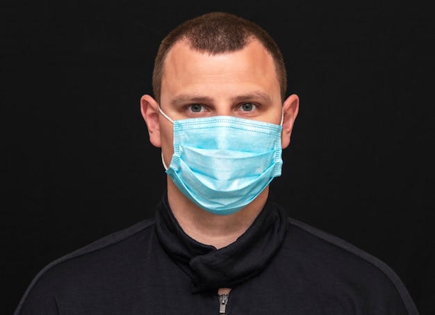 Un homme met un masque médical sur son visage, des instructions sur la façon de porter un masque