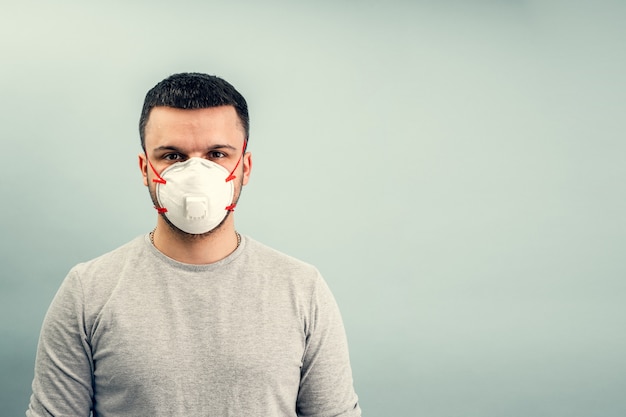 Un homme met un masque de protection. Protection respiratoire contre les coronavirus. Équipement de protection individuelle en cas de pandémie d'infection virale. Covid19.