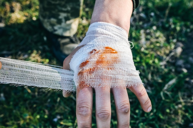 L'homme met un pansement sur une plaie saignante Main blessée Touriste dans la nature Danger d'infection Traitement médical