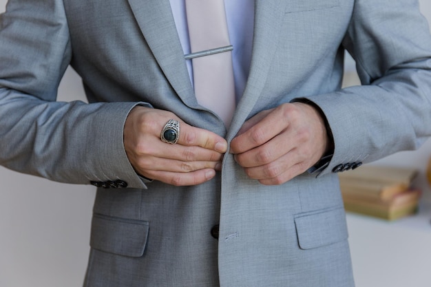 Photo l'homme met une veste de costume grise