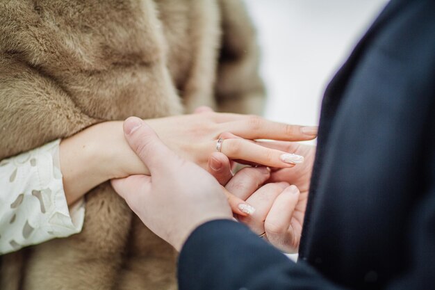 Homme mettant la bague de mariage sur la main de la femme