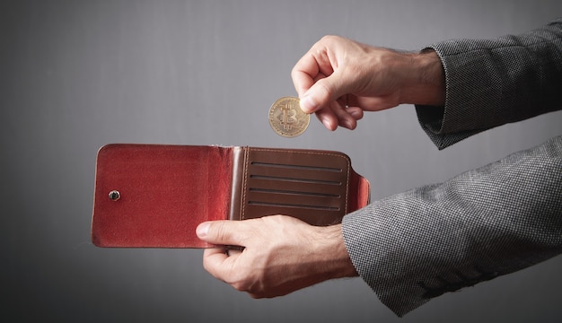 Homme mettant Bitcoin dans son portefeuille.