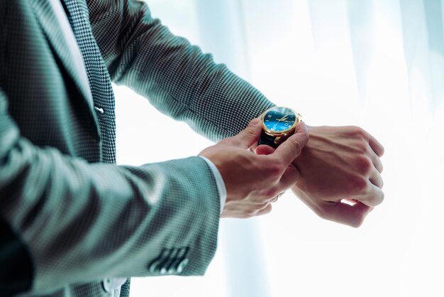 Homme mettant l'horloge sur le marié se préparant le matin