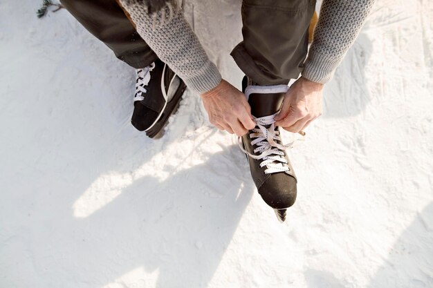 Homme mettant des patins à glace