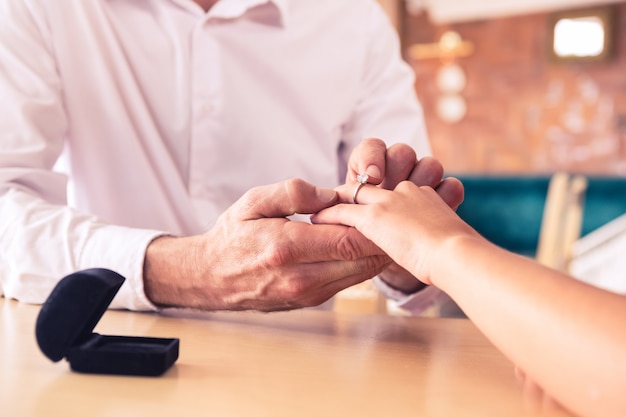 Homme, mettre, bague fiançailles, sur, doigt femme