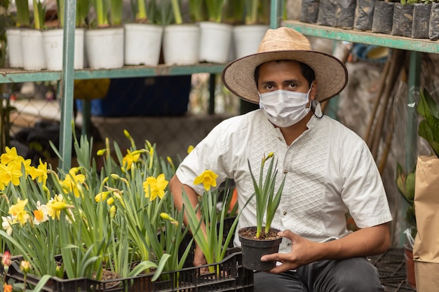 Homme mexicain travaillant dans une pépinière portant un masque facial, nouvelle norme