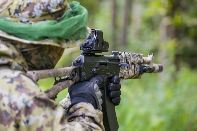 Homme militaire dans la forêt avec une mitrailleuse. Formation et éducation des soldats. L'homme est prêt à tirer