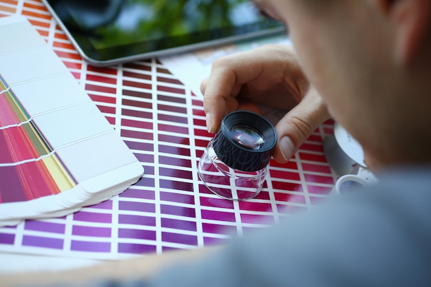 Photo homme militaire tenir dans la main loupe faisant un test de couleur