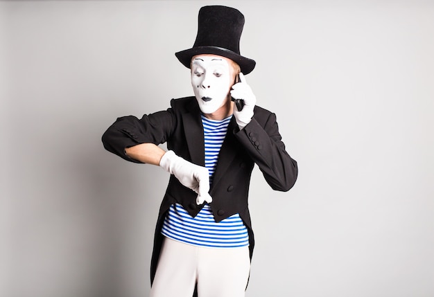 L'homme mime parle sur son téléphone portable. Concept du poisson d'avril.