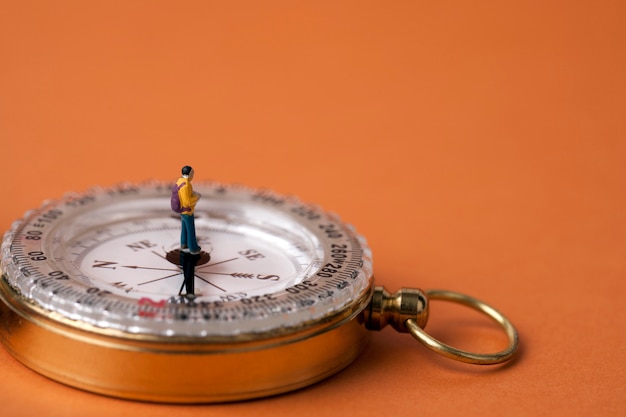 homme miniature debout sur une boussole