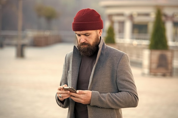 Homme de mode avec barbe hipster caucasien brutal avec moustache Homme barbu Hipster mature avec barbe Homme de soin de coiffeur homme tapant un message sur smartphone être en ligne appeler le taxi