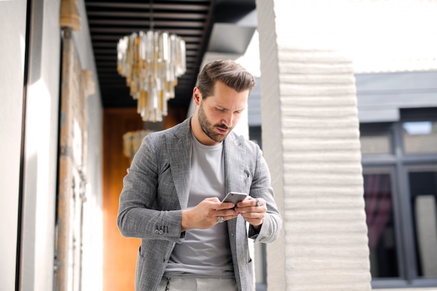 Homme à la mode utilisant son smartphone