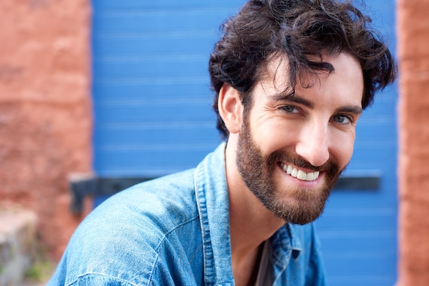 Homme moderne branché avec une barbe en souriant