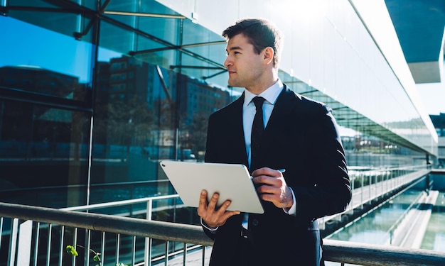 Homme moderne confiant avec tablette et stylet