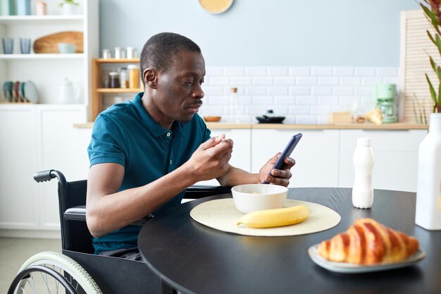 Homme moderne handicapé au petit-déjeuner