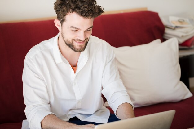 Homme moderne hipster beau travail à la maison en utilisant un ordinateur portable