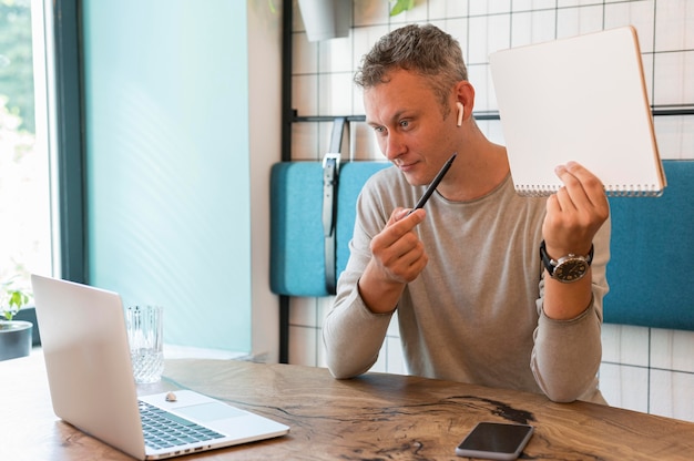 Homme moderne montrant des notes sur appel vidéo