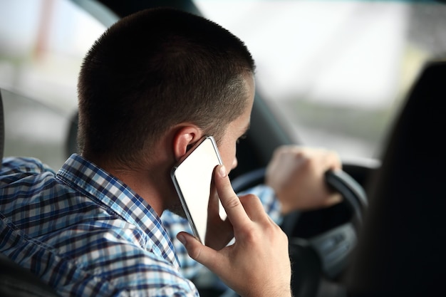 homme moderne parlant sur un smartphone, assis dans la voiture