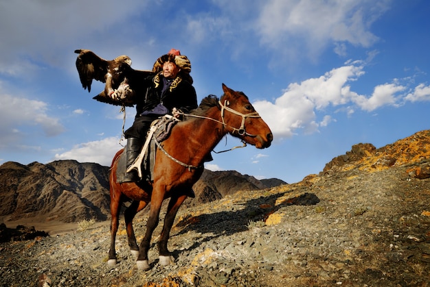 Homme mongol sur un cheval avec un aigle