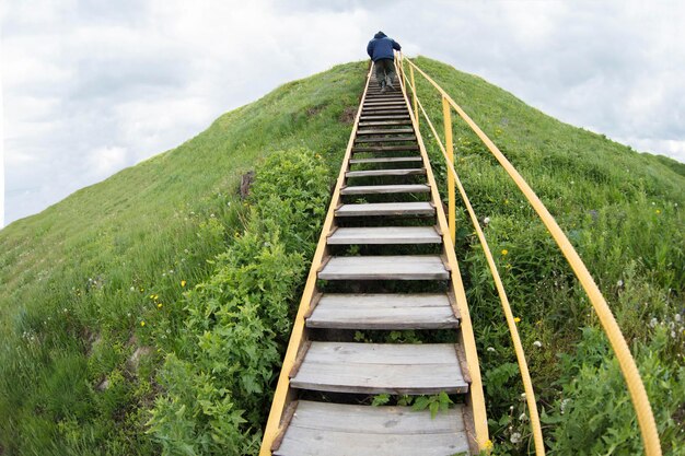 Un homme monte une échelle sur une colline