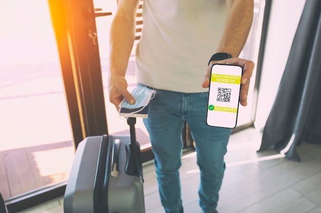 L'homme montrant une application de passeport de santé numérique sur un téléphone portable pour voyager.