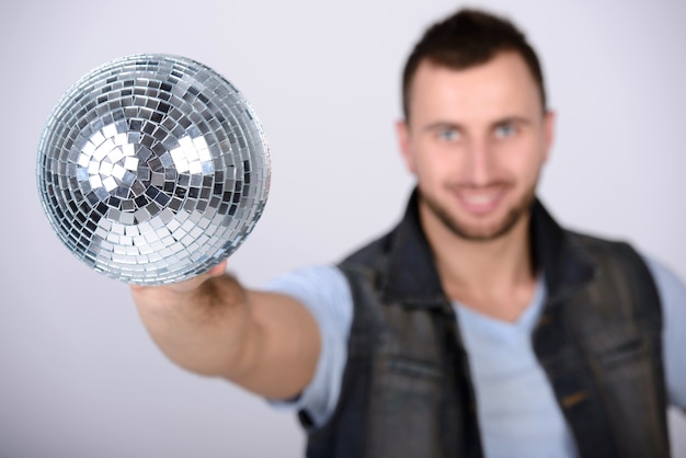 Photo homme montrant une boule brillante disco