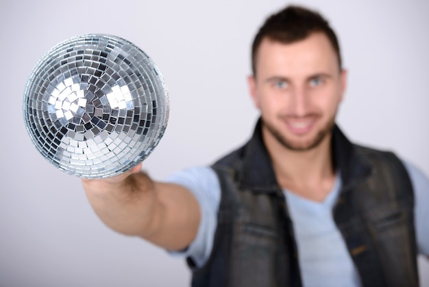 Homme montrant une boule brillante disco