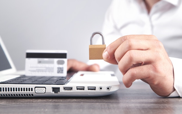 Homme montrant un cadenas. Carte de crédit, internet, sécurité informatique