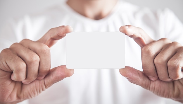 Homme montrant une carte de visite vide.