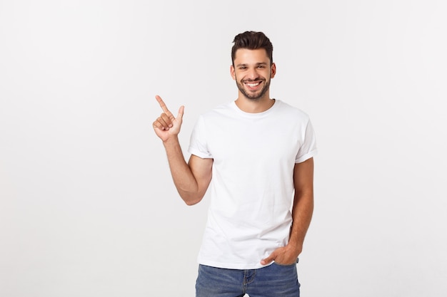 Homme montrant l'espace copie isolé sur mur blanc. Casual beau jeune homme caucasien.