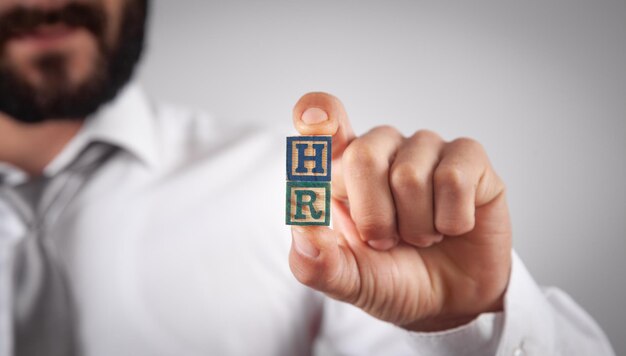 Homme montrant le mot HR sur des cubes en bois