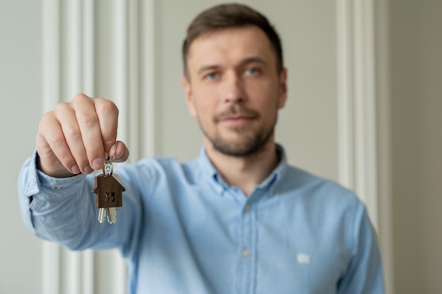 L'homme montre les clés de son nouvel appartement dans le salon