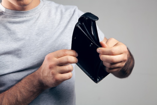 L'homme montre un portefeuille en cuir vide.