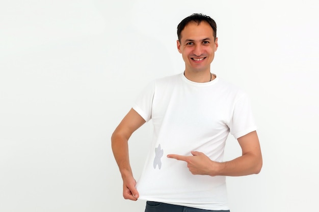 l'homme montre une tache sur son t-shirt blanc