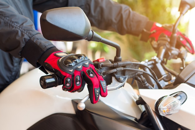 Homme en moto avec des gants est un vêtement de protection important pour la moto