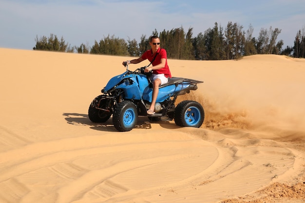 Un homme à moto sur le sable