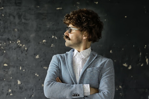 homme moustachu dans un costume classique et lunettes vintage, portrait hipster bouclé, cheveux longs