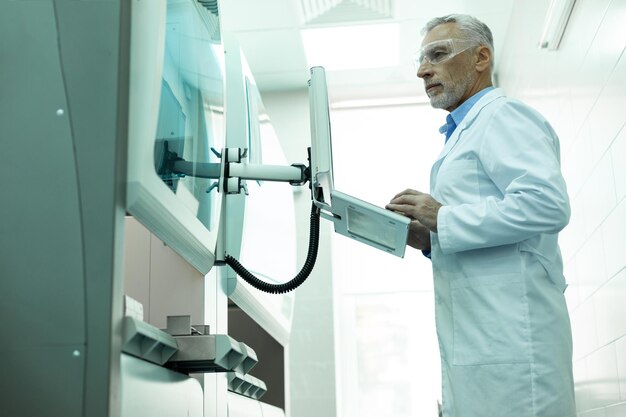 Photo homme mûr attentif travaillant dans une clinique moderne