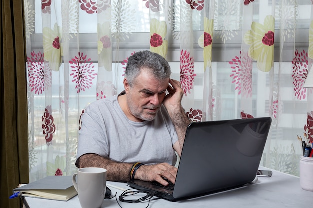 Homme mûr avec une barbe travaillant à la maison