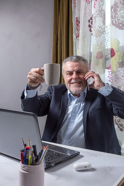 Homme mûr avec une barbe travaillant à la maison