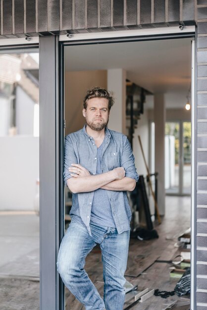 Homme mûr debout dans la porte de sa nouvelle maison