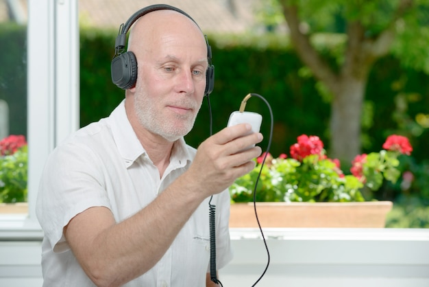 Homme mûr, écouter musique, à, sien, téléphone