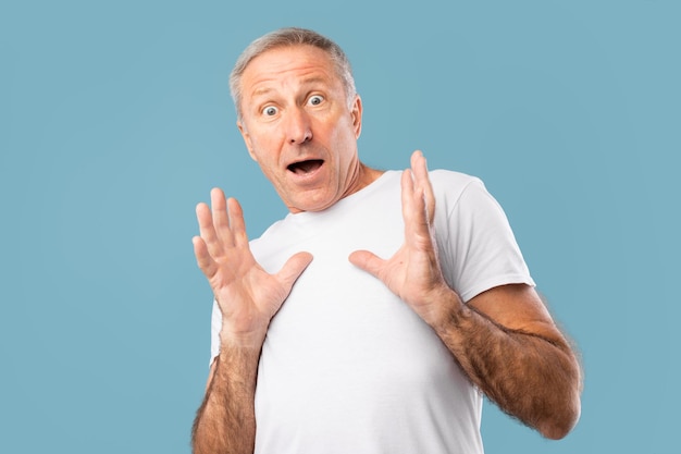 Homme mûr effrayé regardant fixement l'appareil-photo au studio